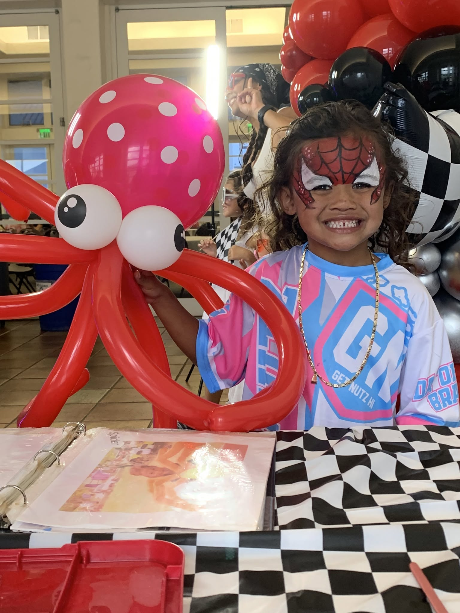 Child with spiderman face paint and balloon animal